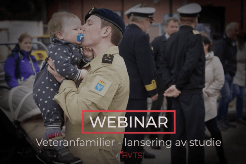 En uniformert soldat kysser et lite barn på kinnet mens han holder det i armene. Andre uniformerte personer står i den uskarpe bakgrunnen. Teksten lyder WEBINAR Veteranfamilier - lansering av studie (RVTS).